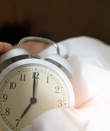 Inertie du sommeil : pourquoi le réveil est si dur Main eteignant un reveil qui sonne au petit matin