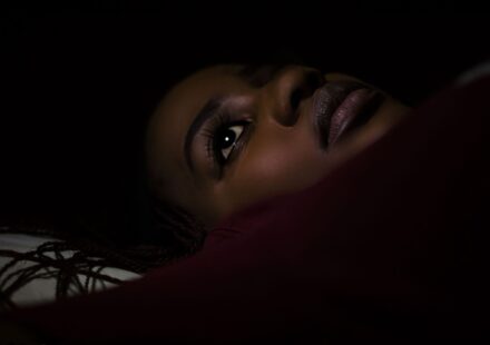 Paralysie du sommeil : causes, sensations et solutions Personne allongee dans une chambre sombre la nuit