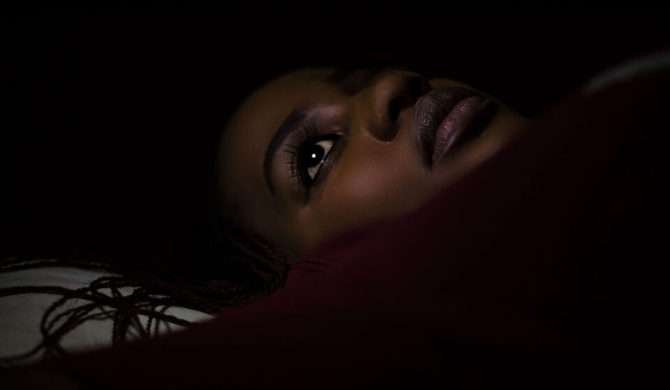 Personne allongee dans une chambre sombre la nuit
