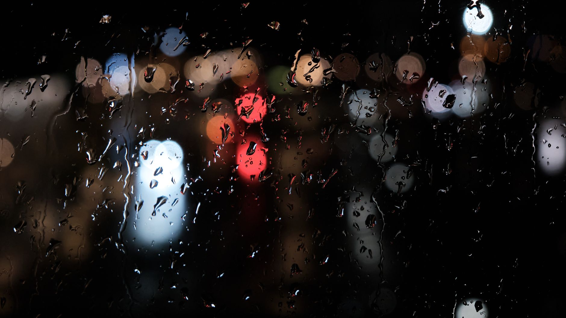 Gouttes de pluie sur une fenêtre la nuit, proche du bruit rose
