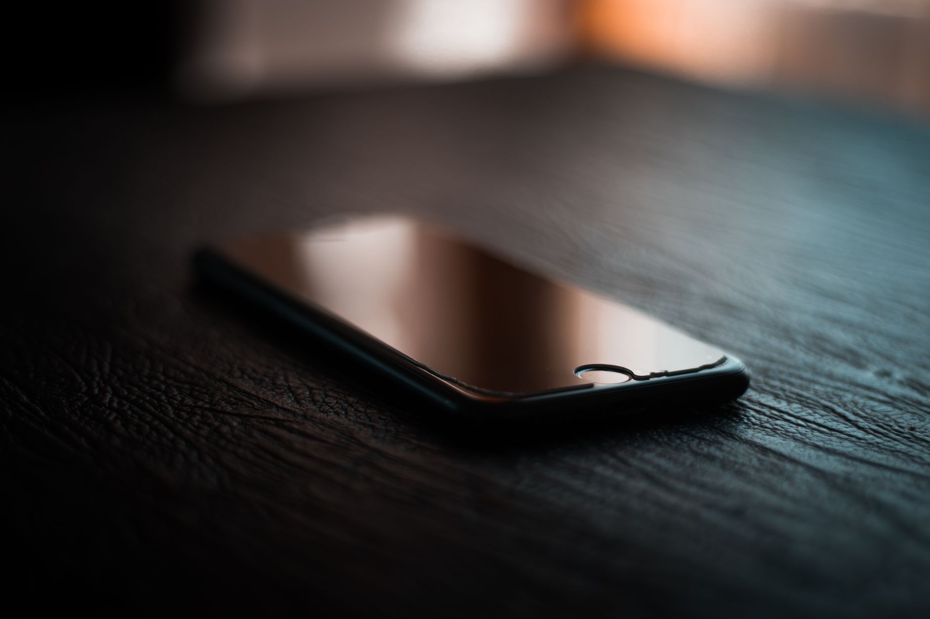 Smartphone posé sur une table de nuit faiblement éclairée