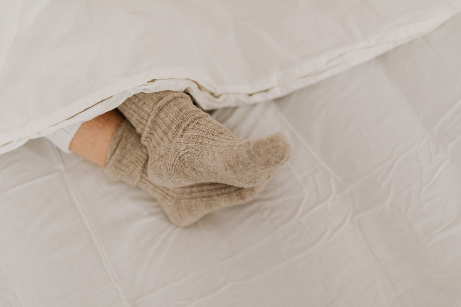 Pieds en chaussettes de laine sous une couverture
