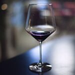 Alcool et sommeil : l’effet réel sur vos nuits Verre de vin rouge sur une table en soiree