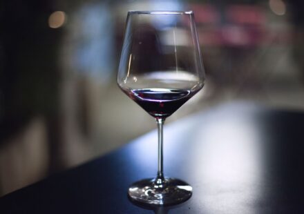 Alcool et sommeil : l’effet réel sur vos nuits Verre de vin rouge sur une table en soiree