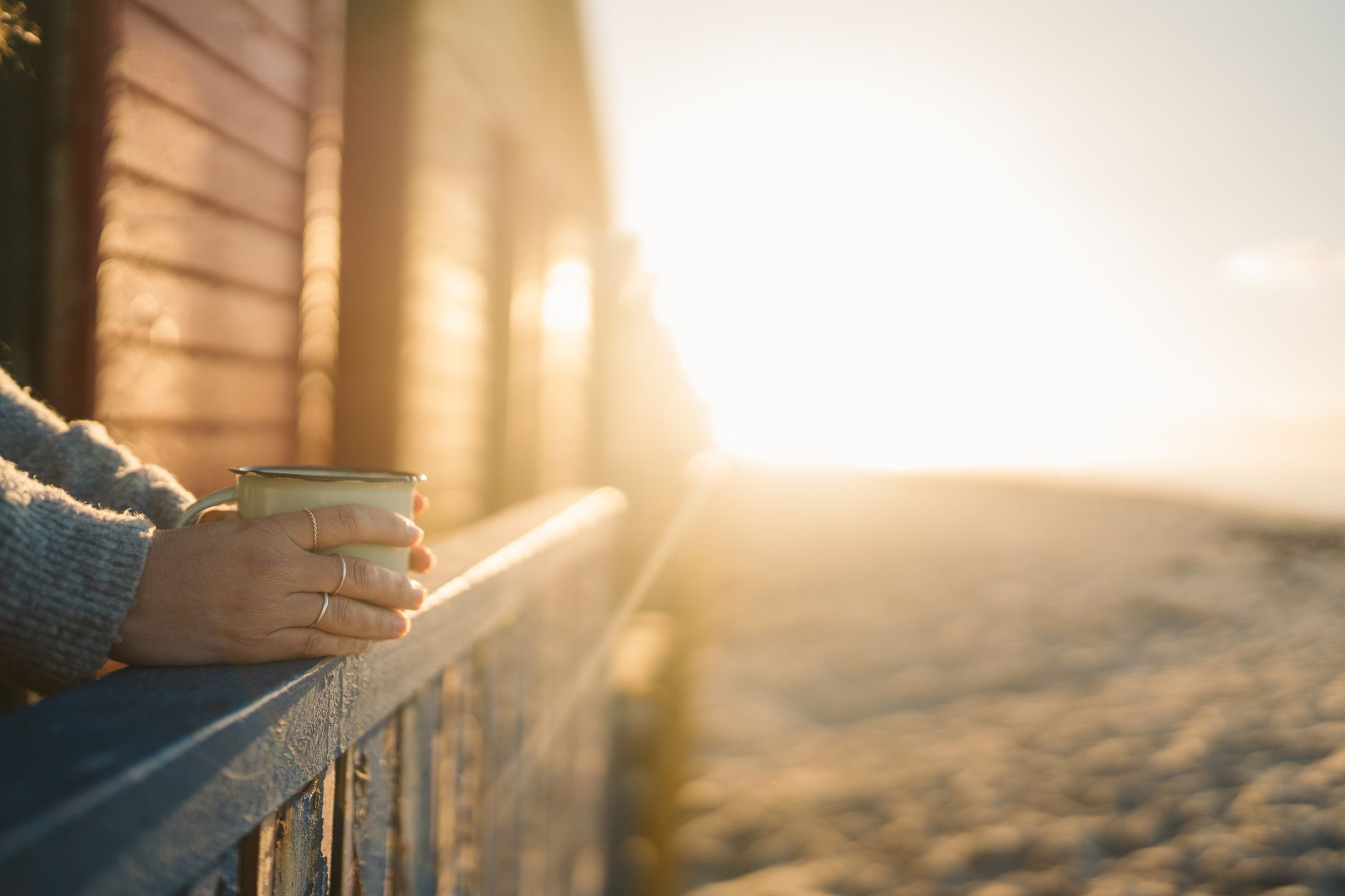 Main tenant une tasse au lever du soleil, lumière du matin