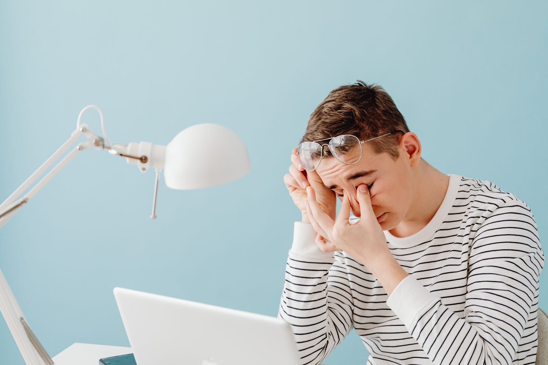 Homme se frottant les yeux de fatigue devant un ordinateur