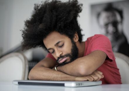 Homme endormi sur son ordinateur portable au bureau