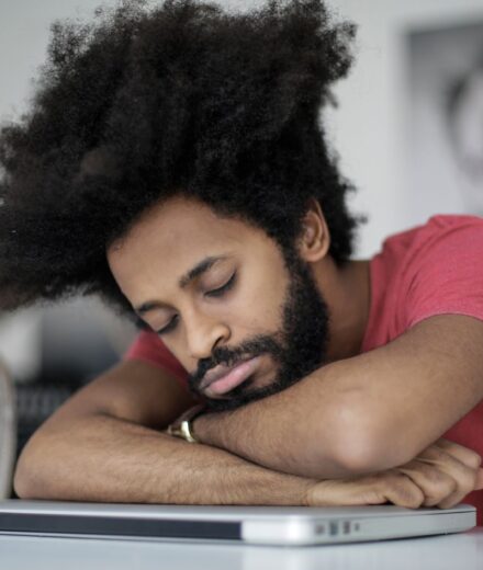 Sommeil polyphasique : mythe ou méthode efficace ? Homme endormi sur son ordinateur portable au bureau