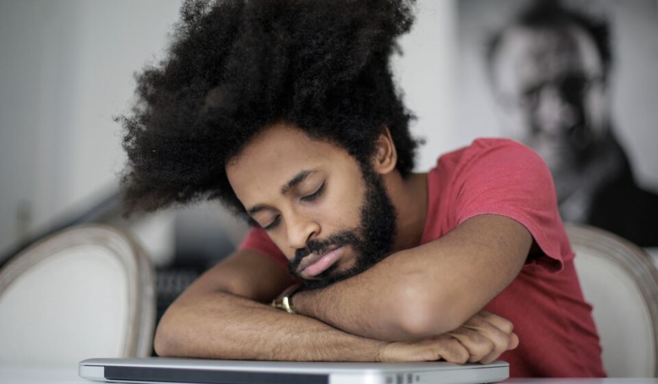 Homme endormi sur son ordinateur portable au bureau