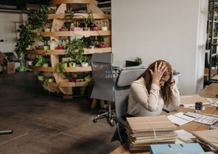 Cortisol : comment réguler l’hormone du stress Femme stressee assise a son bureau, tete dans les mains