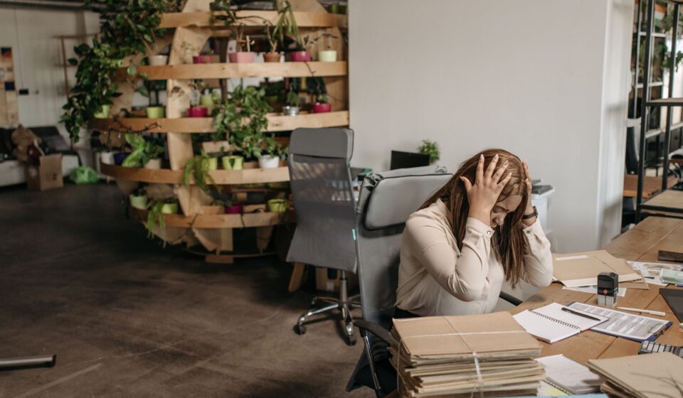 Femme stressee assise a son bureau, tete dans les mains