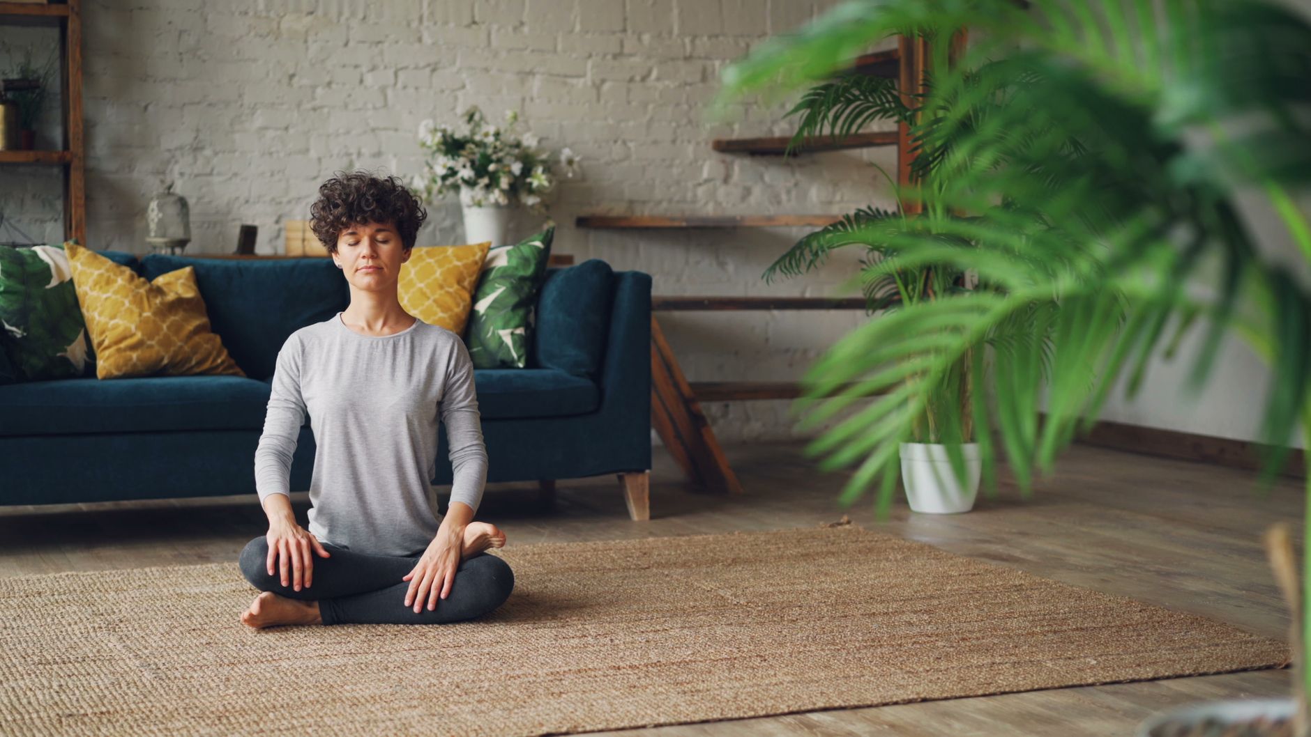 Femme en méditation dans un salon, respiration calme