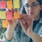 Femme organisant de nombreux post-it, image de la charge mentale