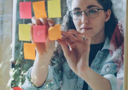 Femme organisant de nombreux post-it, image de la charge mentale