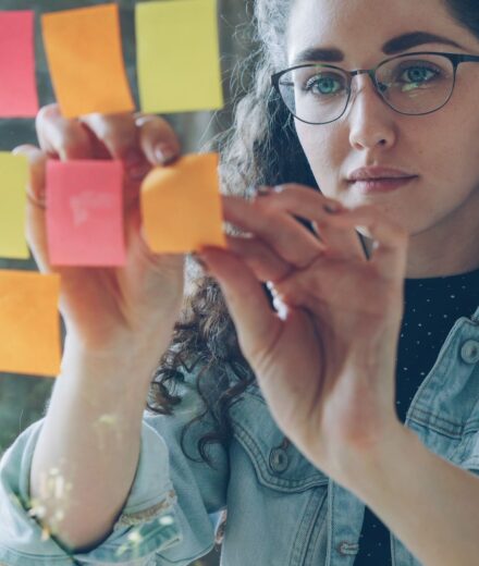 Femme organisant de nombreux post-it, image de la charge mentale