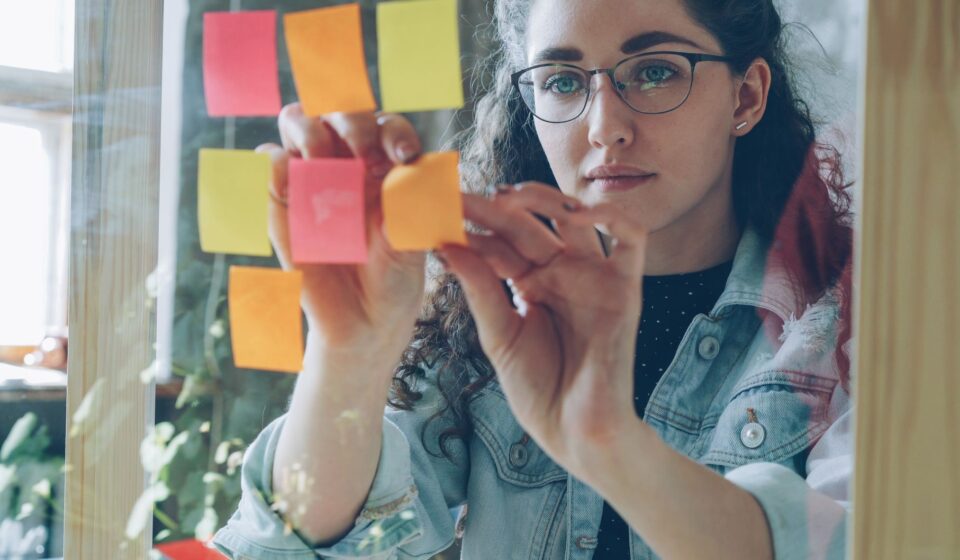 Femme organisant de nombreux post-it, image de la charge mentale