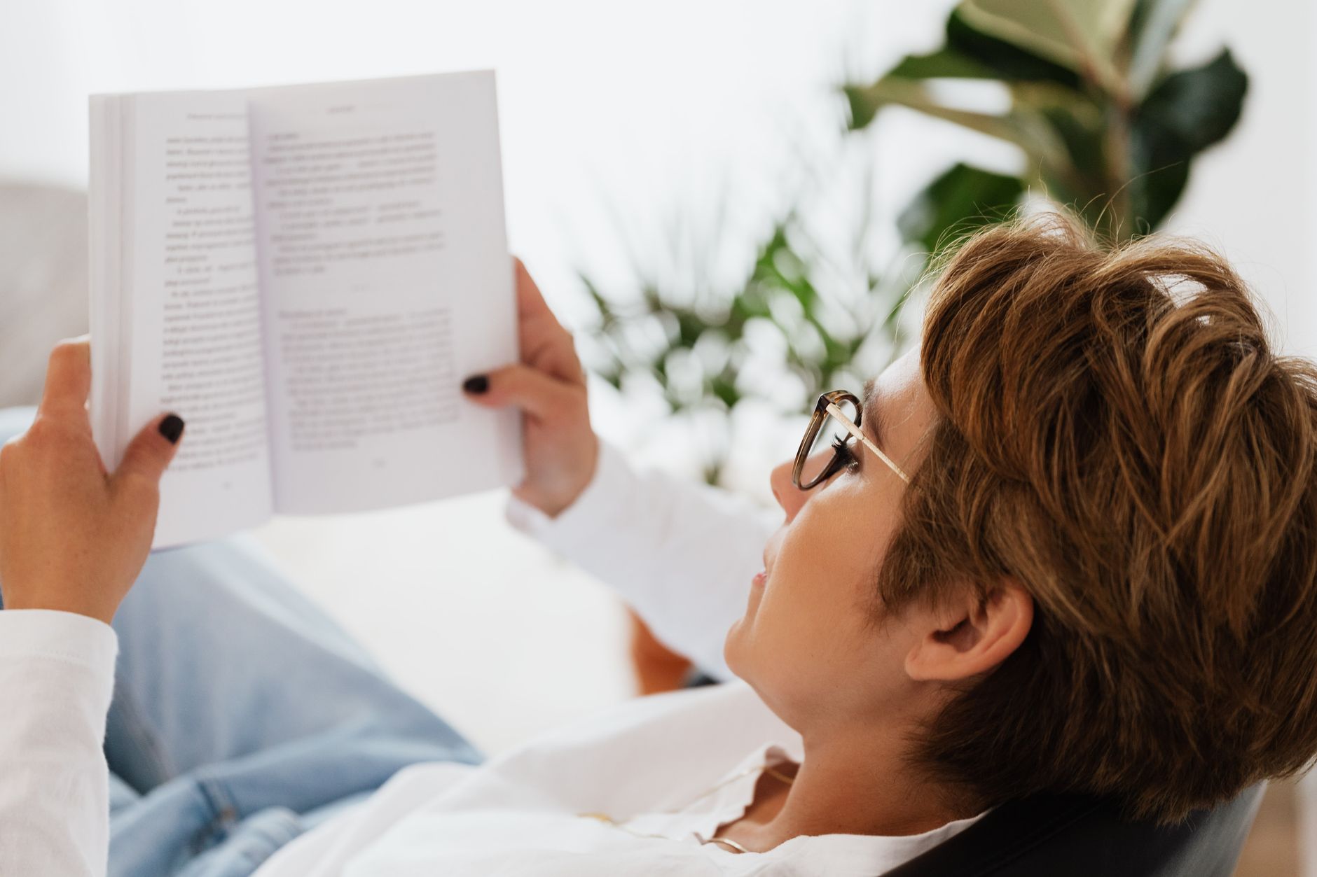 Femme lisant un livre au calme chez elle