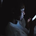 Personne consultant son smartphone la nuit, inquiete