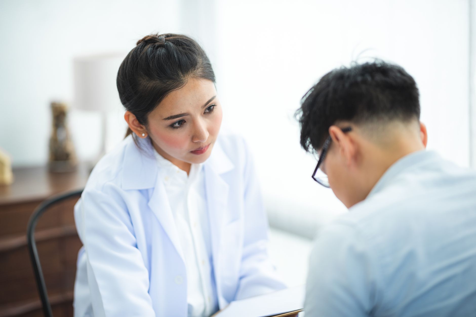 Médecin à l'écoute d'un patient lors d'une consultation