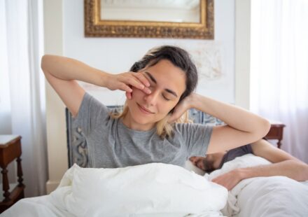 Jeune femme qui s etire au reveil dans son lit le matin
